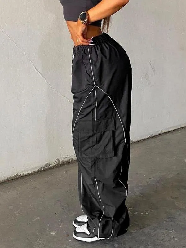 Black parachute trousers with cargo pockets and piping details