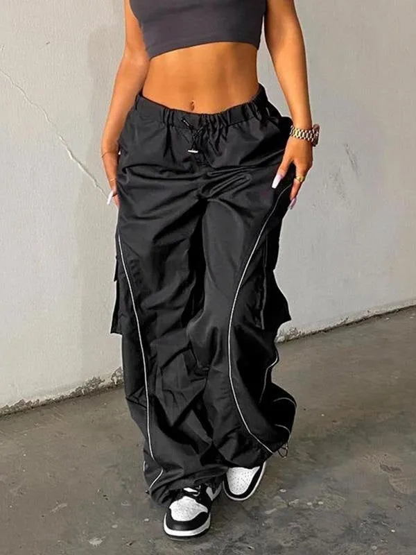 Black parachute trousers with cargo pockets and piping details